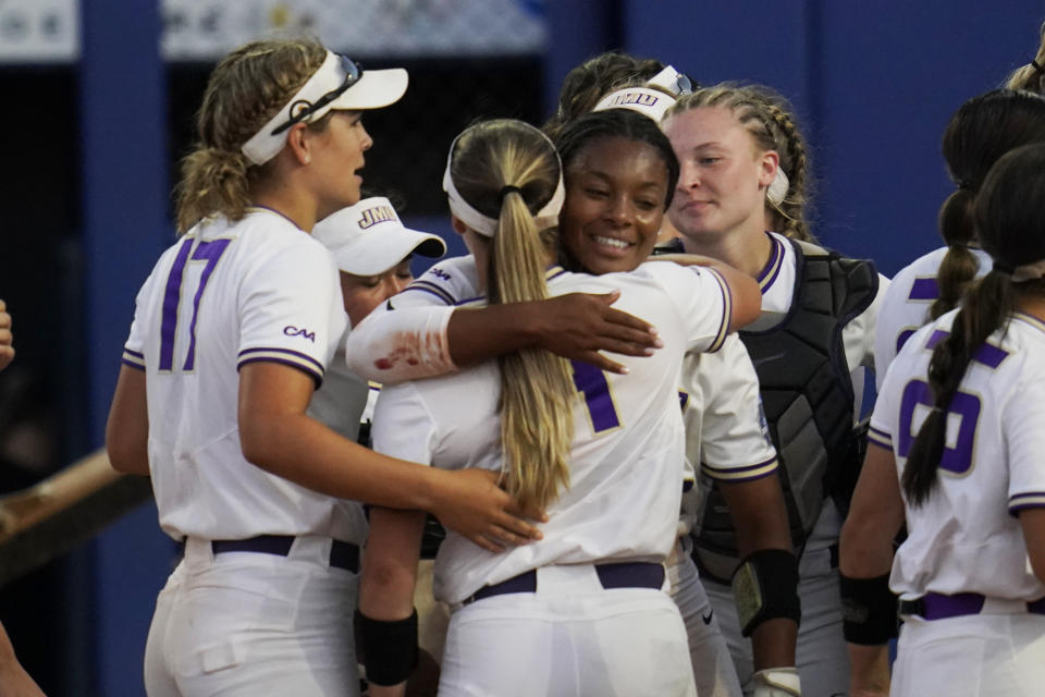 James Madison pitcher Odicci Alexander, center, facing camera, celebrates with teammates after the team's win over Oklahoma State in an NCAA Women's College World Series softball game, Friday, June 4, 2021, in Oklahoma City. (AP Photo/Sue Ogrocki)