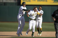 From left to right, Oakland Athletics center fielder Starling Marte, left fielder Mark Canha and second baseman Tony Kemp celebrate defeating the Houston Astros in a baseball game in Oakland, Calif., Sunday, Sept. 26, 2021. The Athletics won 4-3. (AP Photo/John Hefti)