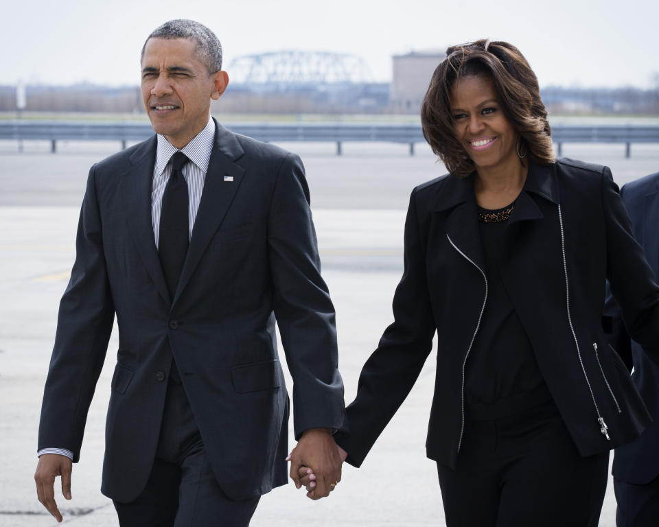 FILE - This April 11,2014 file photo shows President Barack Obama and first lady Michelle Obama smile after disembarking Air Force One at John F. Kennedy International Airport in New York. When President Barack Obama travels abroad, getting just the leader of the free world doesn’t seem to be enough. Countries want the first lady, too. But Michelle Obama won’t join her husband when he heads to Asia next week and her absence is likely to sting, especially in Japan. It’s the first of four countries on Obama’s travel schedule and the only one welcoming him on an official state visit. (AP Photo/John Minchillo, File)