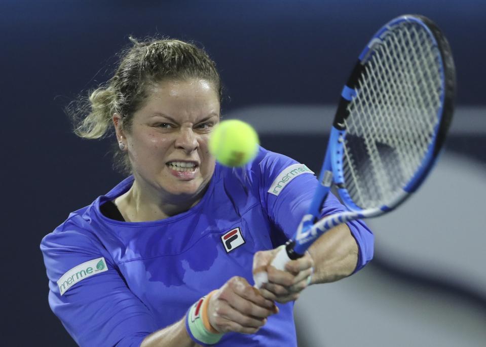 FILE - In this Feb. 17, 2020, file photo, Belgium's Kim Clijsters returns the ball to Spain's Gabrine Muguruza during a match of the Dubai Duty Free Tennis Championship in Dubai, United Arab Emirates. Any World TeamTennis player or coach who tests positive for COVID-19 when arriving for the three-week 2020 season will be dropped from the league without pay. The health plan released Tuesday, June 16, 2020, by the WTT for its matches starting July 12 at The Greenbrier in West Virginia also calls for two daily temperature checks for spectators, no ball kids, a chair umpire aided by electronic line-calling instead of line judges, and no high-fives or handshakes between opponents. The rosters announced for the WTT's nine teams include Grand Slam title winners Kim Clijsters, Sloane Stephens, Sofia Kenin and the Bryan brothers. (AP Photo/Kamran Jebreili, File)