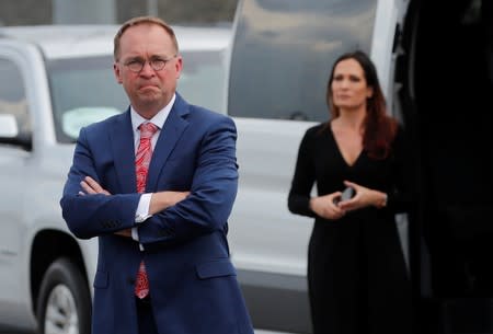 White Chief of Staff Mick Mulvaney and Stephanie Grisham, spokesperson for first lady Melania Trump, wait by a van after their arrival in Orlando