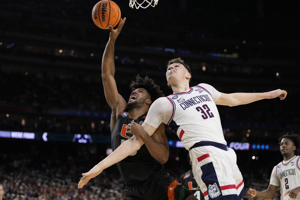 Miami forward Norchad Omier drives to the basket past Connecticut center Donovan Clingan during the second half of a Final Four college basketball game in the NCAA Tournament on Saturday, April 1, 2023, in Houston. (AP Photo/David J. Phillip)