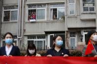 Residents bid farewell from their homes to a medical team from Guizhou province who is leaving Wuhan, following the novel coronavirus disease (COVID-19) outbreak, in Hubei