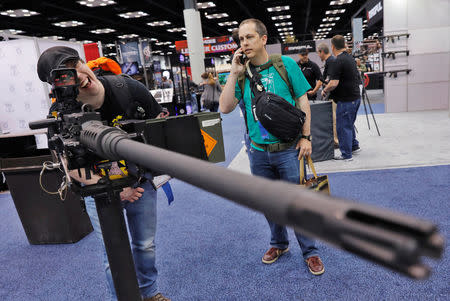 A man looks through the sights of a .50 caliber rifle at the Ohio Ordinance Works during the National Rifle Association (NRA) annual meeting in Indianapolis, Indiana, U.S., April 28, 2019. REUTERS/Lucas Jackson