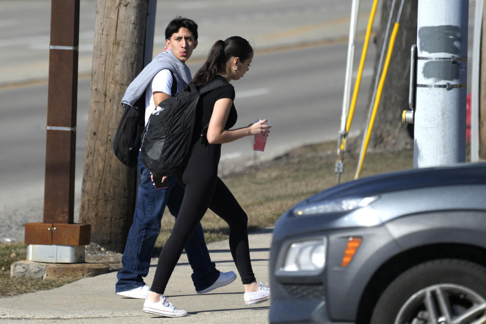 High school students walk cross the street as they wear short sleeves T-shirts in Buffalo Grove, Ill., Tuesday, Feb. 20, 2024. Record warmth is expected today and Tuesday. All time February highest temperature records could also be tied or broken in Illinois. (AP Photo/Nam Y. Huh)