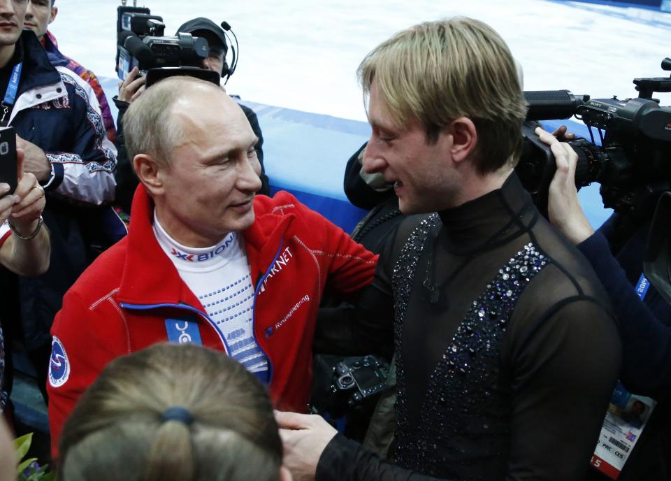 Russian President Vladimir Putin (L) greets Yevgeny Plushenko, a member of the gold medal-winning Russian figure skating team, during the 2014 Sochi Winter Olympics, February 9, 2014. REUTERS/Lucy Nicholson (RUSSIA - Tags: SPORT OLYMPICS FIGURE SKATING POLITICS)