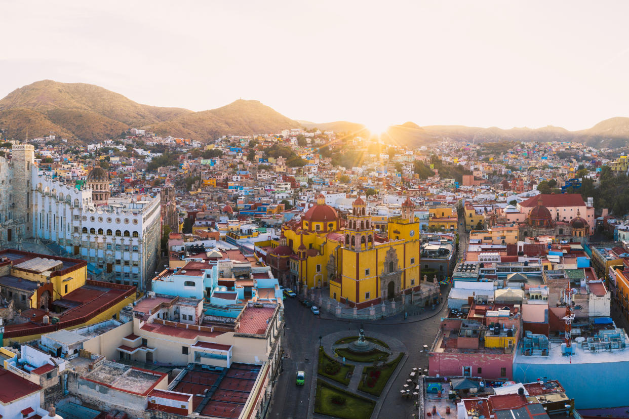Aerial view of the chuch of Parroquia de Basílica Colegiata de Nuestra Señora de Guanajuato and the colorful cityscape at sunrise