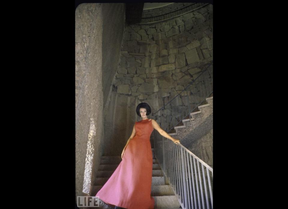 Actress Sophia Loren, who was also considered a fashion icon, in a fabulous pink gown standing on the stone stair hall in her Italian villa, which had 50 rooms. 