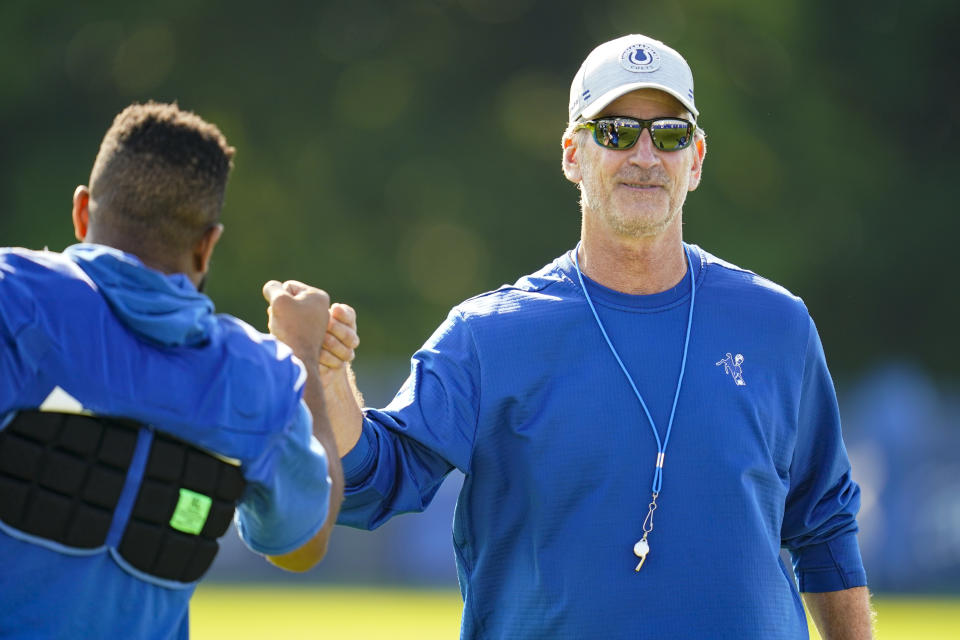 Indianapolis Colts head coach Frank Reich greets players before the start of practice at the NFL team's football training camp in Westfield, Ind., Monday, Aug. 2, 2021. Reich returned to practice following his quarantine period and two negative tests after a positive test for COVID-19. (AP Photo/Michael Conroy)