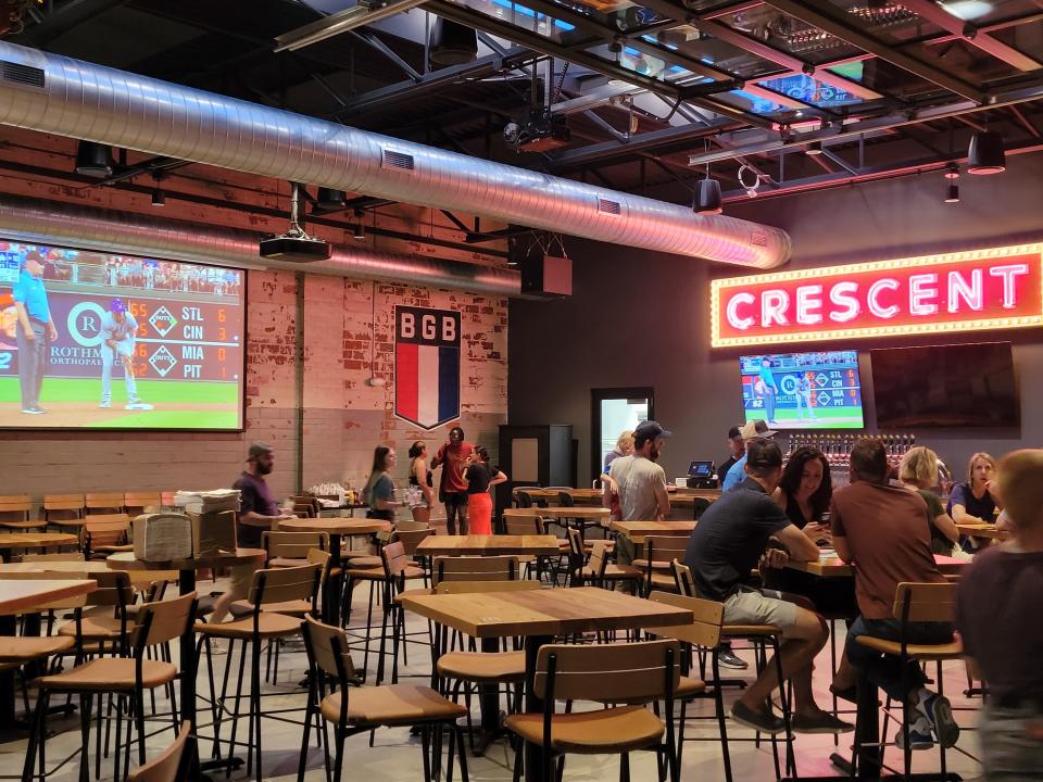 A bright "Crescent" sign shines inside Big Grove Brewery & Taproom on Saturday, July 23, 2022, in Des Moines. The sign is a nod to history of the building, which was built in the 1960s and housed Crescent Chevrolet for decades.