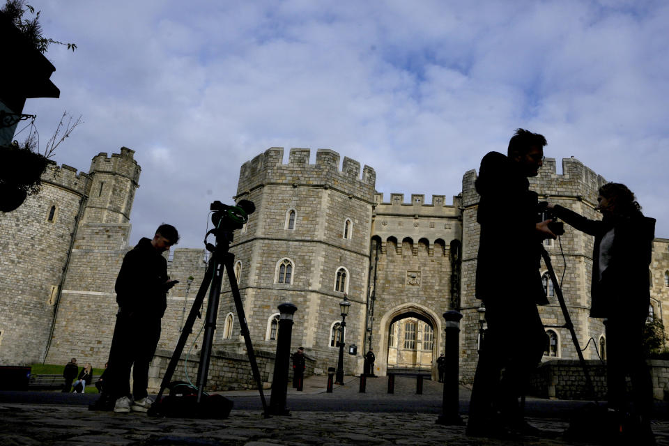 TV news crews report outside Windsor Castle, in Windsor, England, Friday, Oct. 22, 2021. Britain's Queen Elizabeth II spent a night in a hospital for checks this week after canceling an official trip to Northern Ireland on medical advice, Buckingham Palace said Thursday. The palace said the 95-year-old British monarch went to the private King Edward VII's Hospital in London on Wednesday for "preliminary investigations." It said she returned to her Windsor Castle home at lunchtime on Thursday, "and remains in good spirits."(AP Photo/Kirsty Wigglesworth)