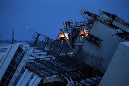 Salvage crew workers are seen on a side of the capsized cruise liner Costa Concordia outside Giglio harbour