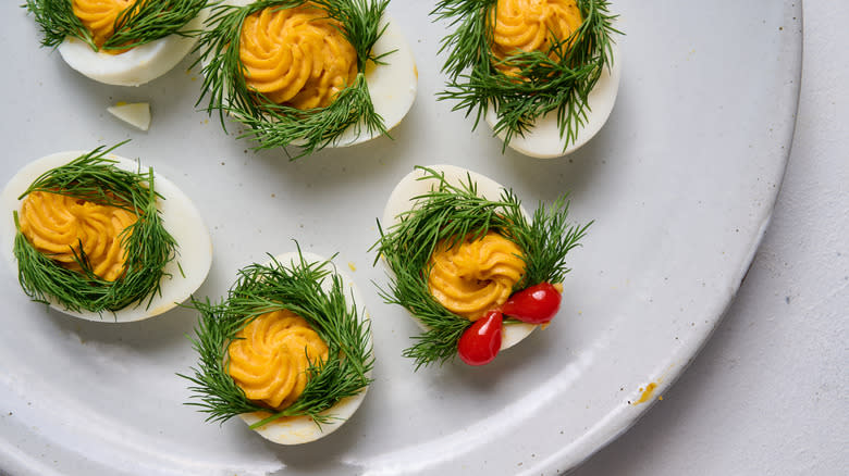 deviled eggs with dill wreaths and pepper bows