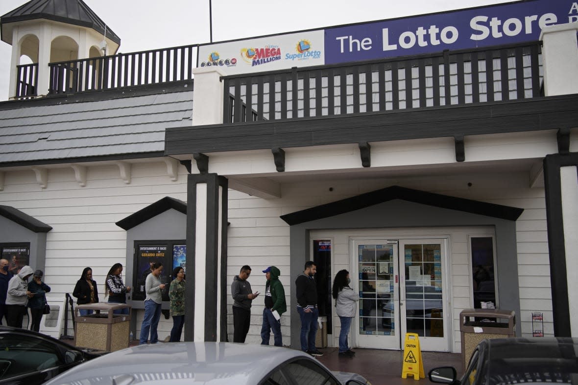 People wait in line at the Lotto Store at Primm just inside the California border, Friday, Jan. 13, 2023, near Primm, Nev. Mega Millions players will have another chance Friday night to end months of losing and finally win a jackpot that has grown to $1.35 billion. (AP Photo/John Locher)