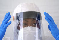 Registered nurse April Lewis puts on a face shield before the start of testing at a newly opened United Memorial Medical Center COVID-19 drive-thru testing site Monday, April 27, 2020, in Houston. (AP Photo/David J. Phillip)