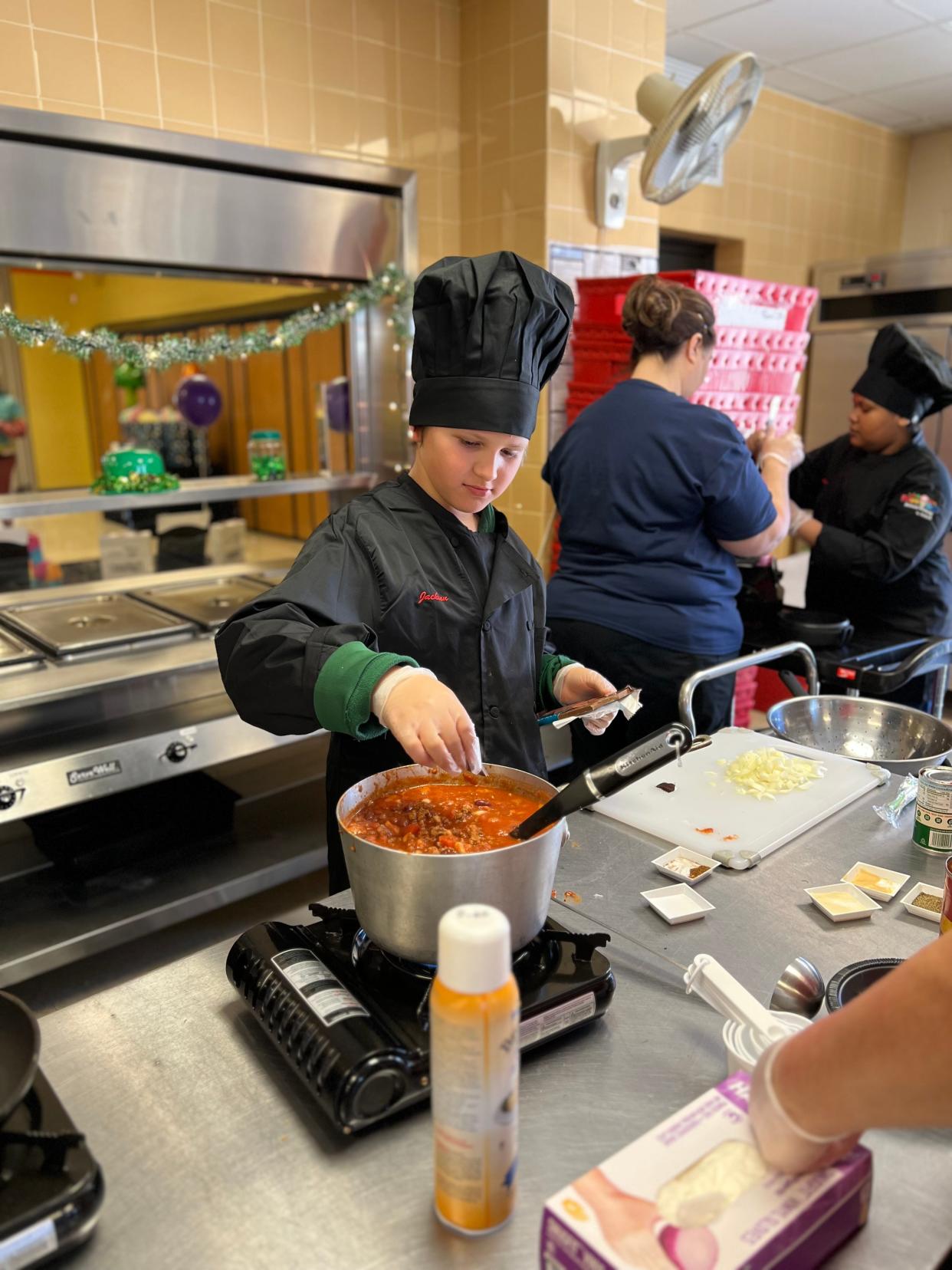 Jackson Sudak, a sixth grader at Arborwood North Elementary School, adds chocolate to his chili during the local competition of the Sodexo National Future Chefs Challenge.
