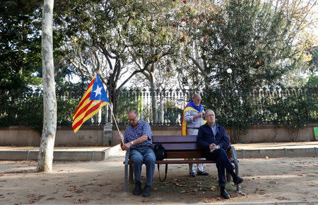 A man holding a Catalan separatist flag sits on a bench outside the Catalan regional parliament in Barcelona, Spain, October 27, 2017. REUTERS/Yves Herman