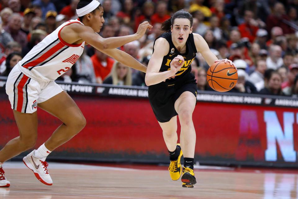 Iowa guard Caitlin Clark, right, dribbles past Ohio State forward Taylor Thierry during the first half of an NCAA college basketball game at Value City Arena in Columbus, Ohio, Monday, Jan. 23, 2023. (AP Photo/Joe Maiorana)