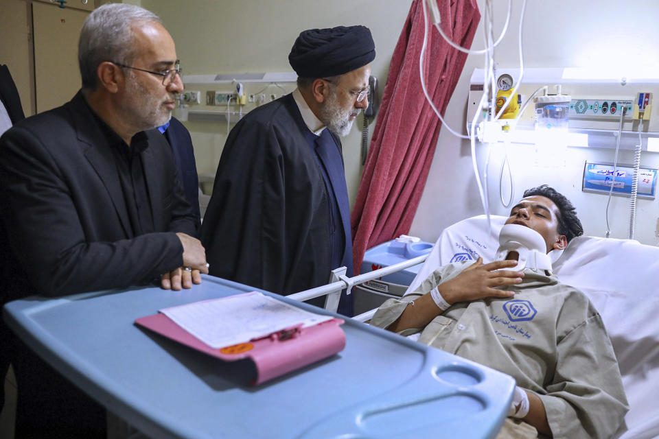 In this photo released by the Iranian Presidency Office, Iranian President Ebrahim Raisi visits a man who was wounded in Wednesday's bomb explosion in the city of Kerman about 510 miles (820 kms) southeast of the capital Tehran, Iran, Friday, Jan. 5, 2024. Iranian officials tried Friday to link Israel and the U.S. to an Islamic State group-claimed suicide bombing, seeking to intertwine the assault with wider Middle East tensions from the Israel-Hamas war. (Iranian Presidency Office via AP)