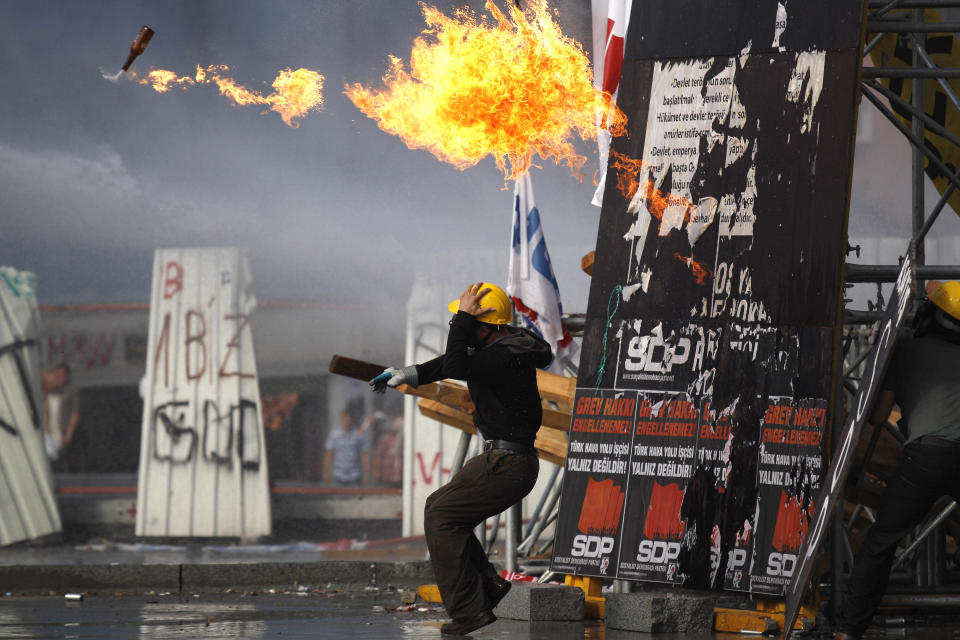 FILE - A protester throws a petrol bomb towards riot policemen during clashes in Taksim Square in Istanbul, Turkey, on June 11, 2013. (AP Photo/Kostas Tsironis, File)