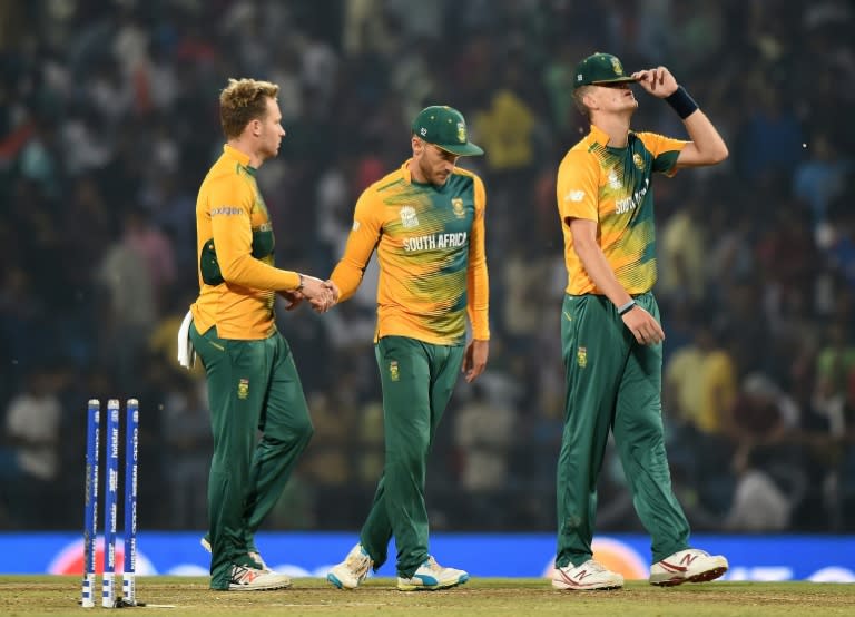 South Africa captain Faf du Plessis (C) and teammates David Miller and Chris Morris (R) walk back towards the pavilion after loosing the World T20 match against West Indies in Nagpur on March 25, 2016