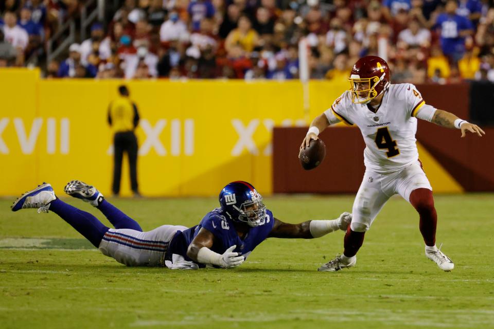 Washington Football Team quarterback Taylor Heinicke scrambles away from New York Giants defensive lineman Leonard Williams in the third quarter at FedEx Field.