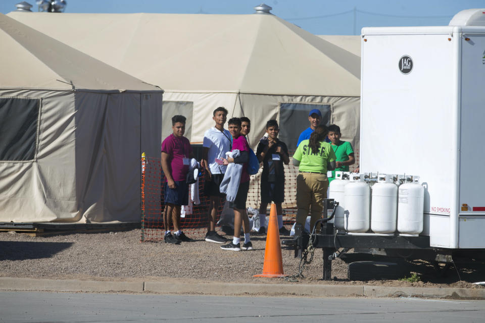 In this Nov. 15, 2018 photo provided by Ivan Pierre Aguirre, migrant teens held inside the Tornillo detention camp look at protestors waving at them outside the fences surrounding the facility in Tornillo, Texas. The Trump administration announced in June 2018 that it would open the temporary shelter for up to 360 migrant children in this isolated corner of the Texas desert. Less than six months later, the facility has expanded into a detention camp holding thousands of teenagers - and it shows every sign of becoming more permanent. (Ivan Pierre Aguirre via AP)