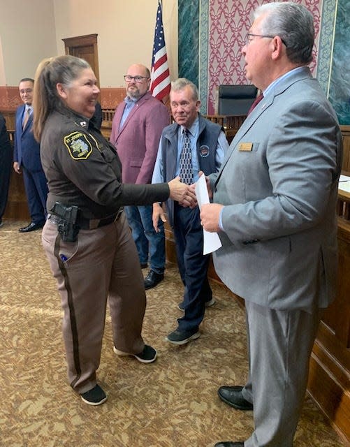 St. Joseph County Sheriff’s Department Capt. Kitty Buchner, jail administrator, is congratulated by county board chairman Ken Malone and other county commissioners Tuesday in Centreville.