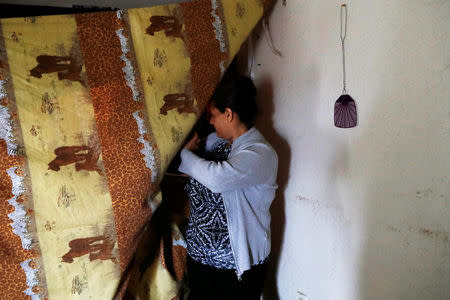 Sandra Gutierrez, who fled from gang violence in Honduras with her family and was granted asylum by the United States in 2016, walks past a curtain to her makeshift bedroom at her home in Oakland, California, U.S., May 30, 2017. Picture taken May 30, 2017. REUTERS/Stephen Lam