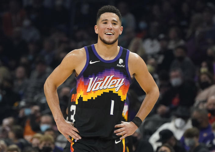 Phoenix Suns' Devin Booker reacts to having a flagrant fouled called against him during the first half of an NBA basketball game against the Miami Heat, Saturday, Jan. 8, 2022, in Phoenix. (AP Photo/Darryl Webb)