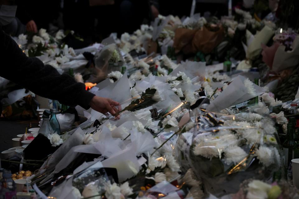 A mourner lays flowers at a tribute site for those killed in the stampede (REUTERS)