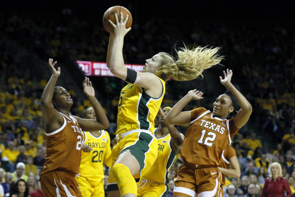 FILE - In this March 5, 2020 file photo, Baylor forward Lauren Cox, center, grabs the rebound between Texas forward Joyner Holmes, left, and guard Jada Underwood, right, during an NCAA college basketball game in Waco, Texas. Cox was selected to The Associated Press women's All-America first team, Thursday, March 19, 2020. Cox earned first-team honors for the first-time. The senior post averaged 12.5 points and 8.4 rebounds while blocking nearly 2.7 shots a game. (AP Photo/Ray Carlin, File)