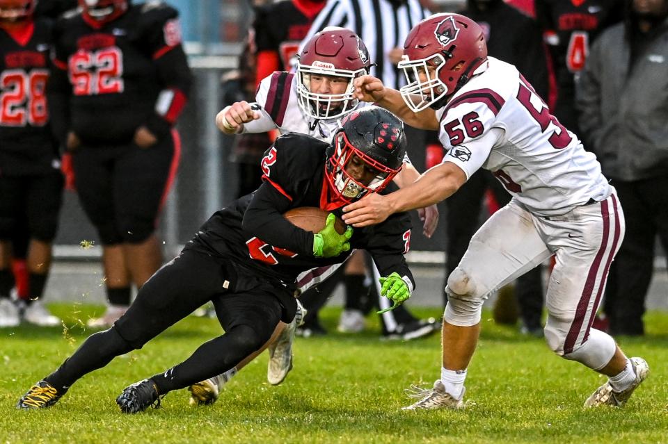 Sexton's Josiah Stewart, left, gets extra yards after a catch as Portland's Mark Meyers, right, closes in during the second quarter on Friday, Oct. 13, 2023, in Lansing.