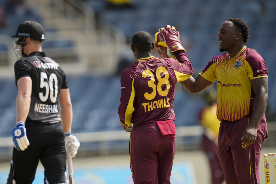 West Indies' bowler Odean Smith celebrates with wicket keeper Devon Thomas the dismissal of New Zealand's James Neesham during the third T20 cricket match at Sabina Park in Kingston, Jamaica, Sunday, Aug. 14, 2022. (AP Photo/Ramon Espinosa)