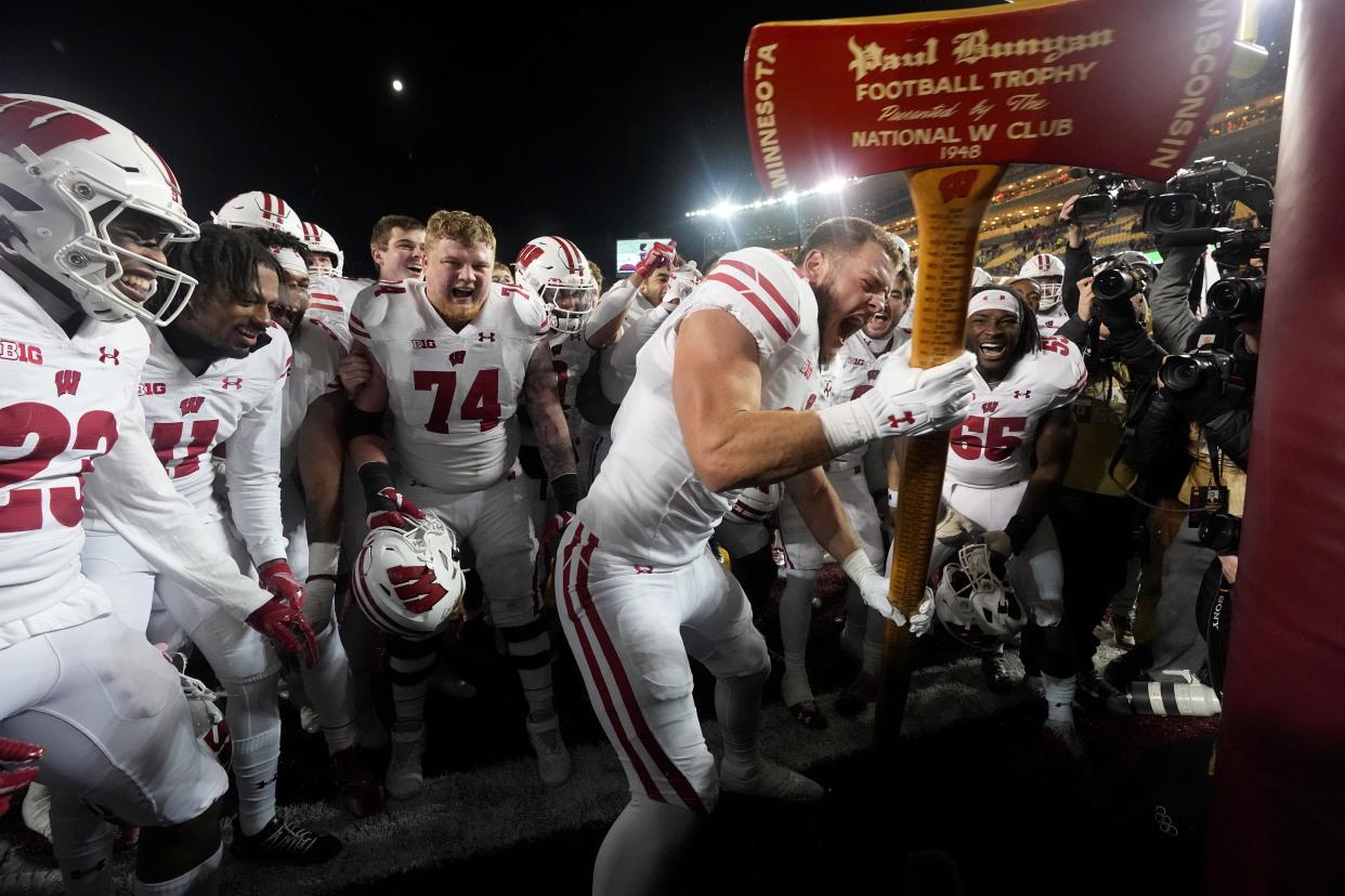 Wisconsin tight end Hayden Rucci and his team celebrate with the Paul Bunyan Axe after the Badgers defeated Minnesota, 28-14, to reclaim the trophy for the first time since 2020.