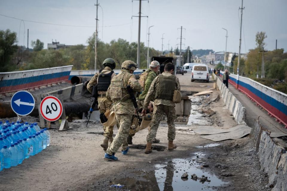 <div class="inline-image__title">1429122648</div> <div class="inline-image__caption"><p>Ukrainian soldiers carry a wounded comrade across a heavily damaged bridge over the Oskil River on Sept. 30, 2022 in Kupiansk, Ukraine. </p></div> <div class="inline-image__credit">Scott Peterson/Getty Images</div>