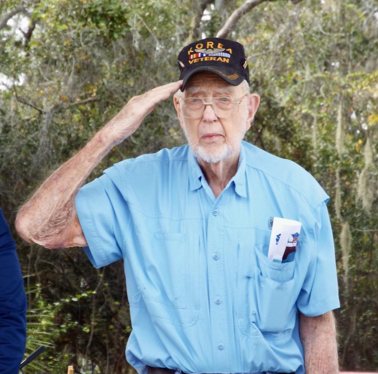 Korean War Veteran John Vevel, 90, of Edgewater salutes as the national anthem is sung by Gina Cuchetti during a Pearl Harbor Remembrance Day ceremony on Sunday,