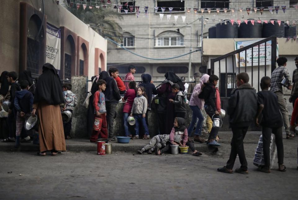 Displaced Palestinians gather to collect food donations before breakfast, on the fourth day of Ramadan, in Rafah on March 14.<span class="copyright">Haitham Imad—EPA-EFE/Shutterstock</span>