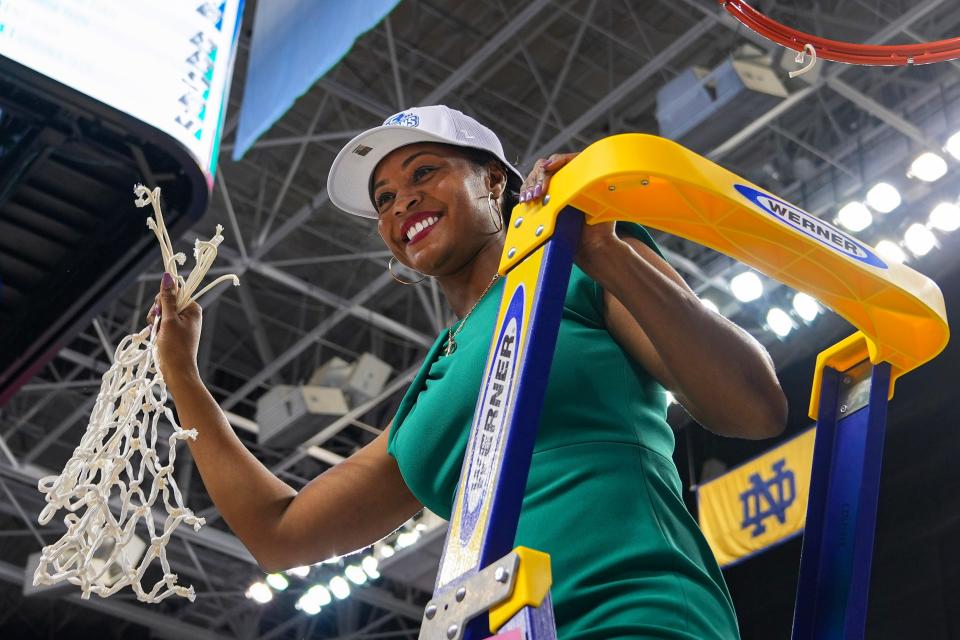 Notre Dame Fighting Irish head coach Niele Ivey displays the tournament net after defeating the NC State Wolfpack at Greensboro Coliseum.