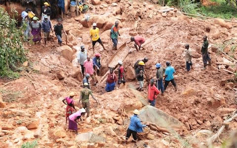 A family dig for their son buried in a mudslide in the aftermath of Cyclone Idai - Credit: Tsvangirayi Mukwazhi/AP