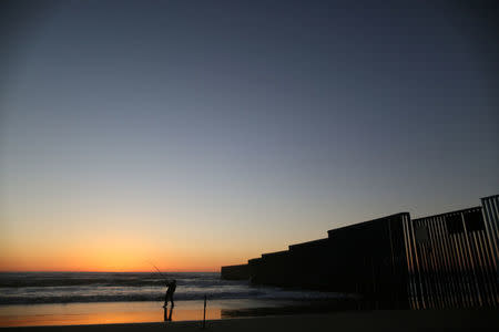 A man is fishing next to the fence separating Mexico and the United States, in Tijuana, Mexico. REUTERS/Edgard Garrido