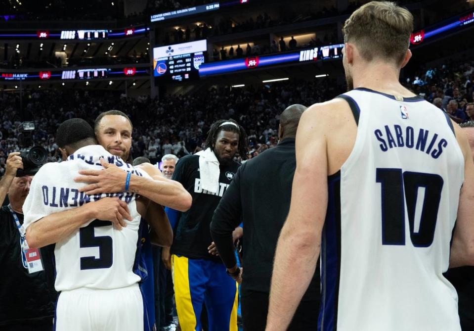 Golden State Warriors guard Stephen Curry (30) hugs Sacramento Kings guard De’Aaron Fox (5) after the Kings beat the Warriors 118-94 in an NBA play-in game at Golden 1 Center on Tuesday.