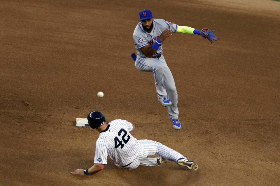 New York Mets shortstop Amed Rosario turns a double play over New York Yankees' Erik Kratz during the sixth inning of the second baseball game of a doubleheader, Sunday, Aug. 30, 2020, in New York. (AP Photo/Adam Hunger)