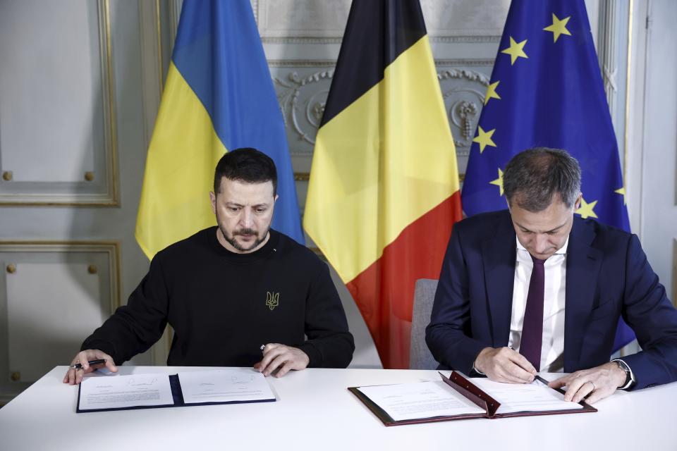 Ukraine's President Volodymyr Zelenskyy, left, and Belgium's Prime Minister Alexander De Croo sign a bilateral security agreement during their meeting at the prime ministers' office in Brussels, Tuesday, May 28, 2024. (Kenzo Tribouillard/Pool Photo via AP)
