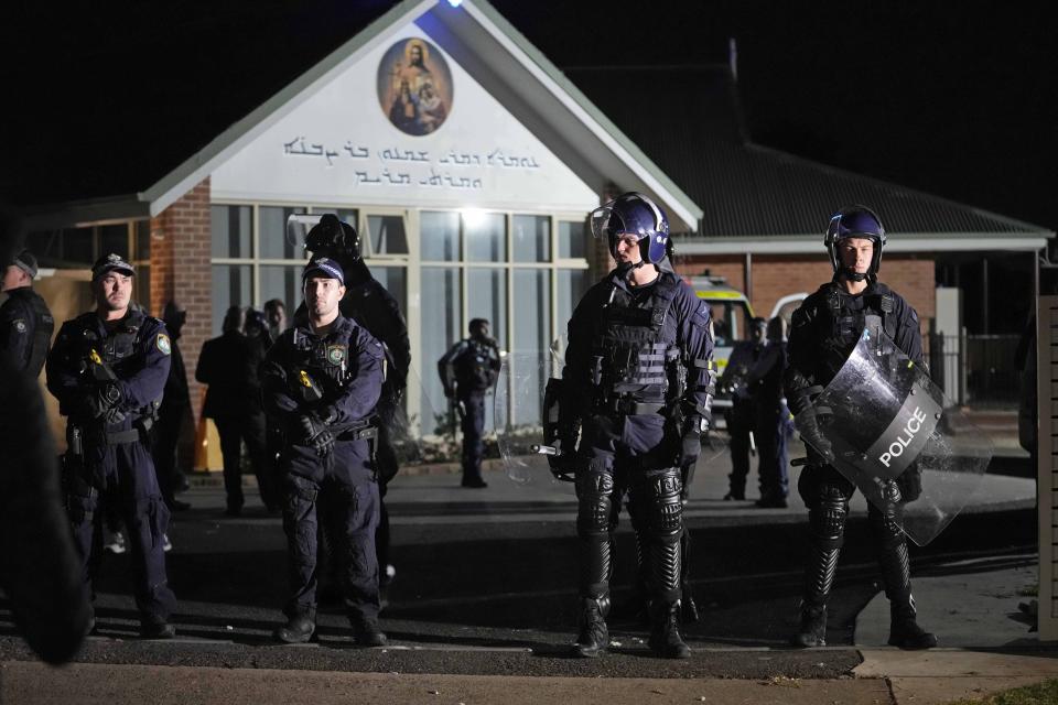 Security officers stand guard outside Orthodox Assyrian church in Sydney, Australia, Monday, April 15, 2024. Police in Australia say a man has been arrested after a bishop and churchgoers were stabbed in the church. There are no life-threatening injuries. (AP Photo/Mark Baker)