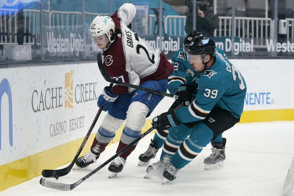 Colorado Avalanche defenseman Ryan Graves (27) skates against San Jose Sharks center Logan Couture (39) and right wing Kevin Labanc during the first period of an NHL hockey game in San Jose, Calif., Wednesday, March 3, 2021. (AP Photo/Jeff Chiu)