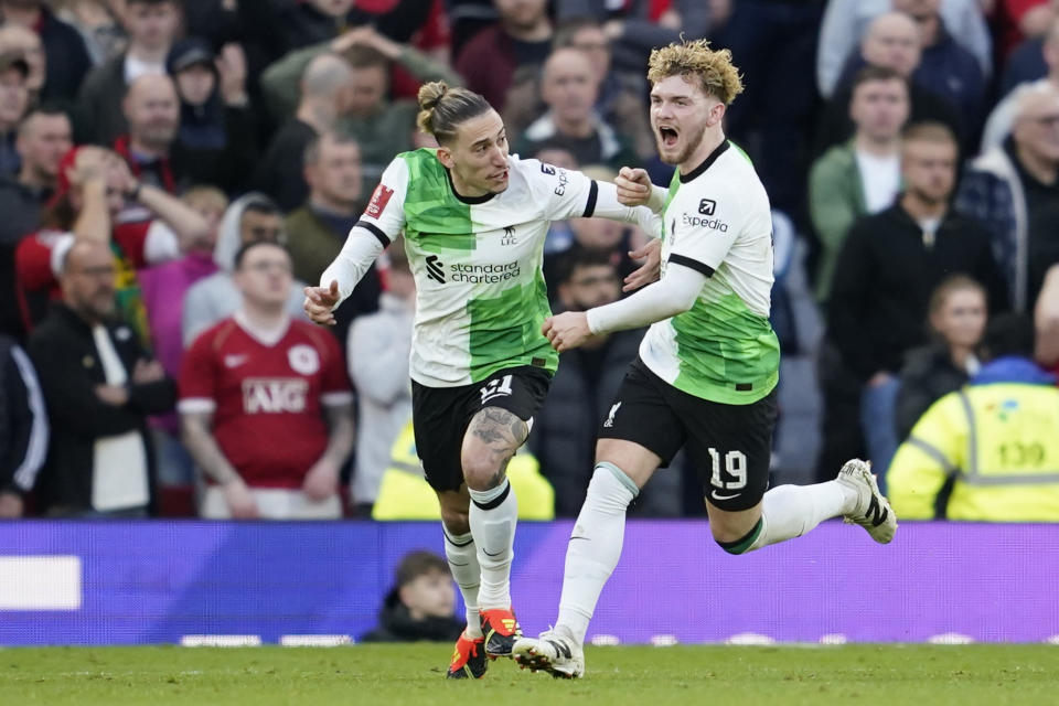 Liverpool's Harvey Elliott, right, celebrates with Liverpool's Kostas Tsimikas after scoring his side's third goal during the FA Cup quarterfinal soccer match between Manchester United and Liverpool at the Old Trafford stadium in Manchester, England, Sunday, March 17, 2024. (AP Photo/Dave Thompson)