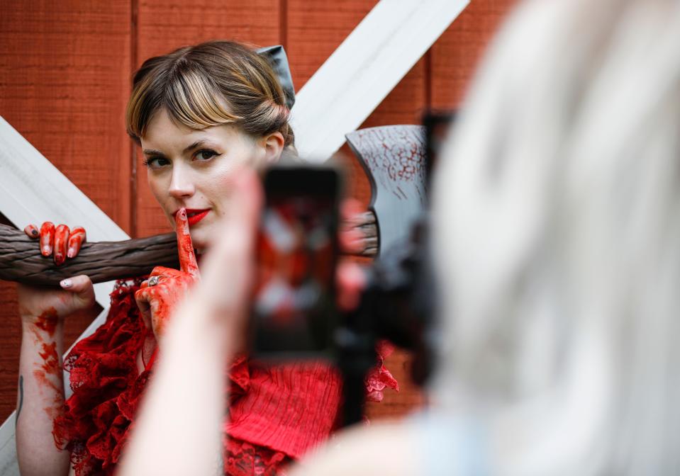 AJ Jenkins, 30, poses for a photo as Heidi Mae Herrington, 34, works a camera and uses her phone to view a photo as a reference as they recreate a movie poster for the slasher-horror film "Pearl" on Thursday, May 4, 2023.