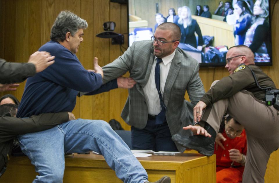 Randall Margraves, left, lunges at Larry Nassar, bottom right, in a Michigan court room. (AP)