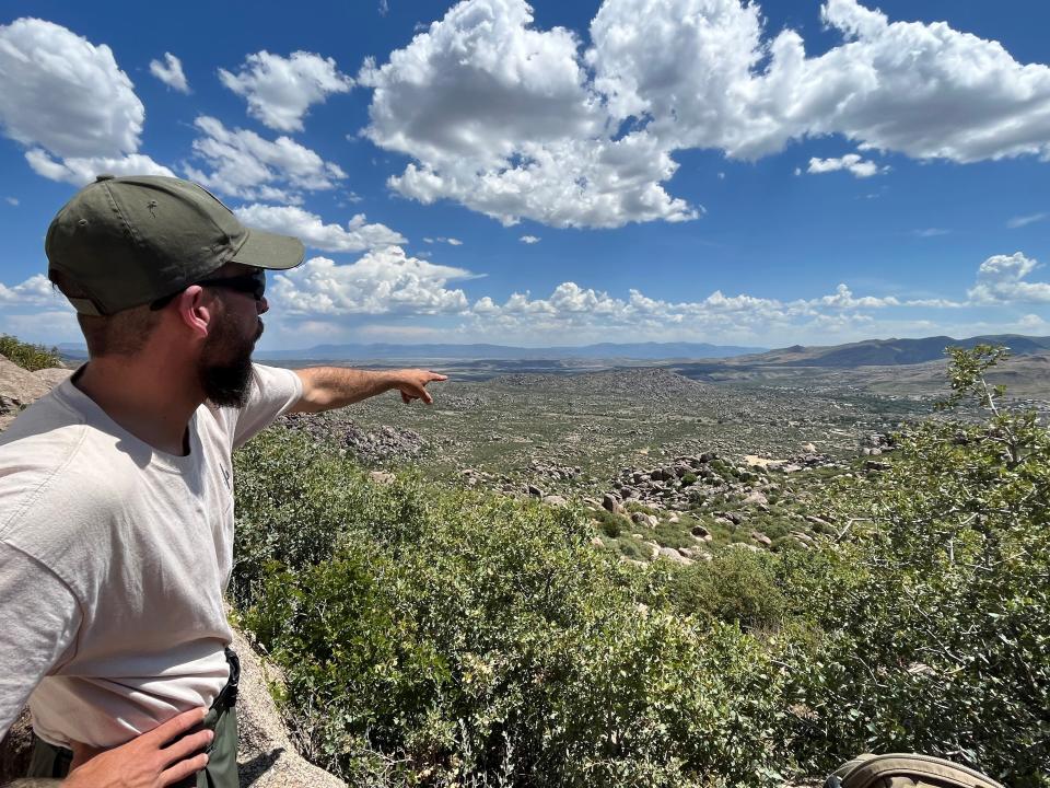 Standing on the Hotshots trail at the Granite Mountain Hotshots Memorial State Park in June 2023, Arizona State Parks Ranger Jared Welsh points to where the Yarnell Hill Fire shifted direction suddenly in response to thunderstorm winds on June 30, 2023, overtaking the 19 firefighters who lost their lives that day.